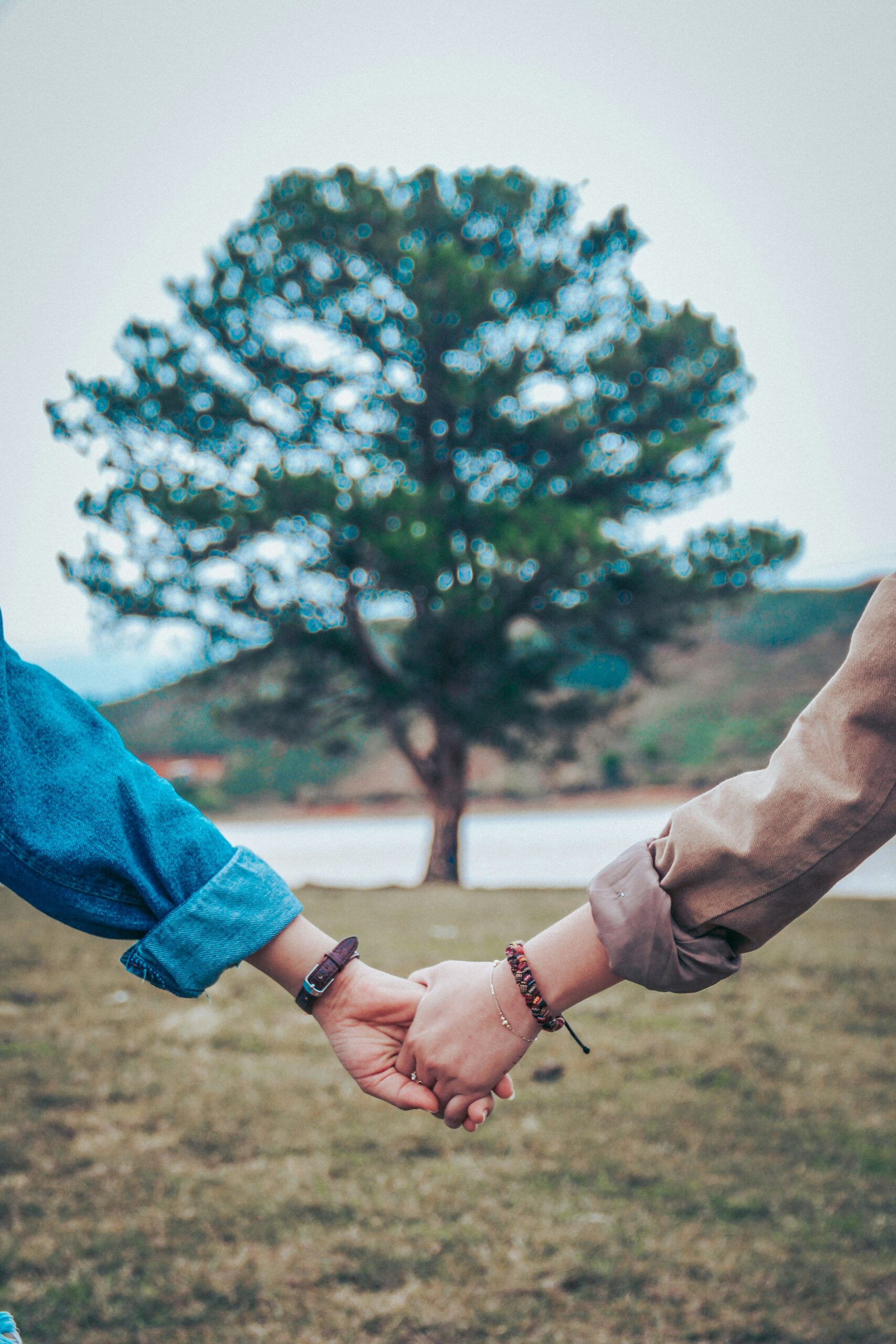 Close up of two people holding hands outside, while speaking about how to set healthy boundaries with each other.